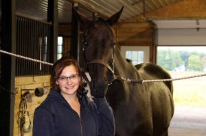 Image of a young woman and a horse inside Walden Ridge's stable